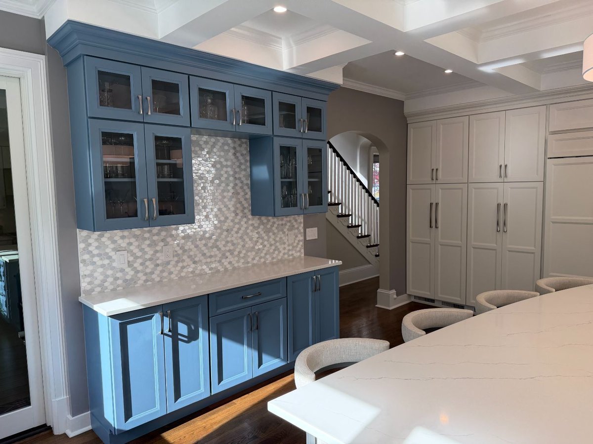 Remodeled kitchen featuring custom blue glass-front cabinetry and quartz countertops in Chevy Chase, MD.