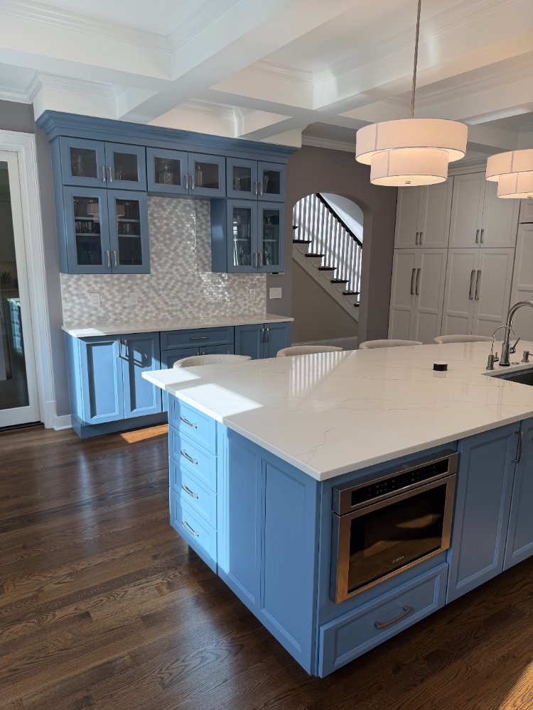 Remodeled kitchen featuring a blue built-in hutch and spacious quartz island in Chevy Chase, MD.