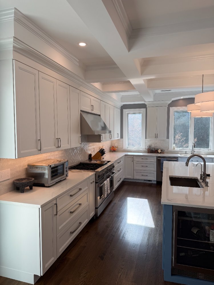Remodeled kitchen showcasing custom cabinetry, quartz countertops, and a blue island in Chevy Chase, MD.
