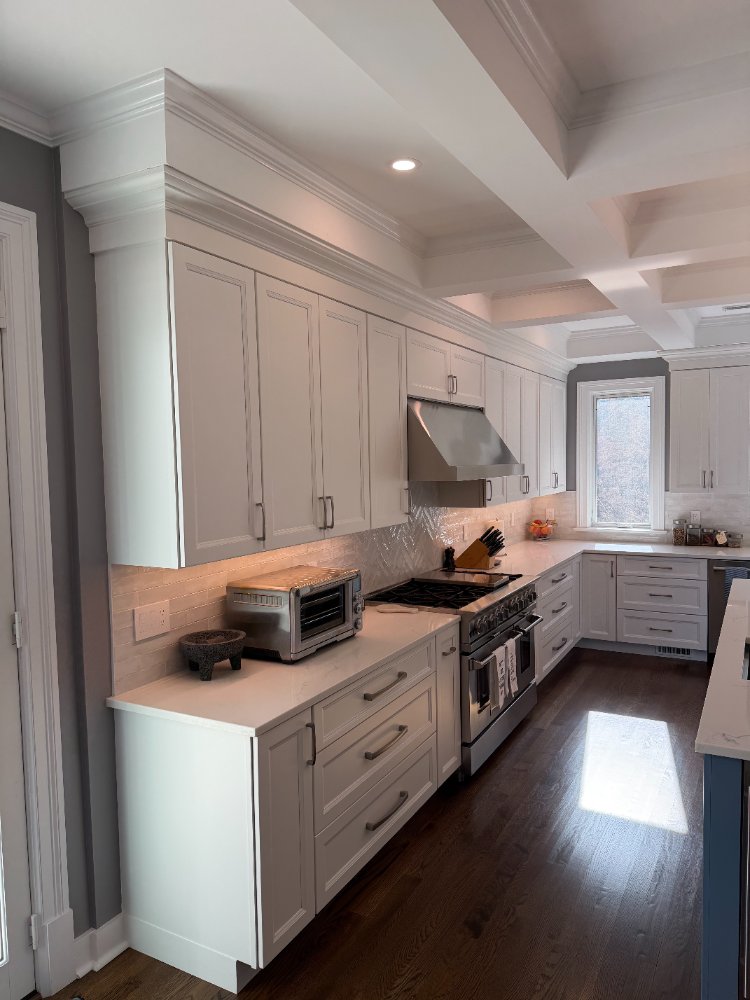 Remodeled kitchen with custom white cabinetry, quartz countertops, and a professional gas range in Chevy Chase, MD.