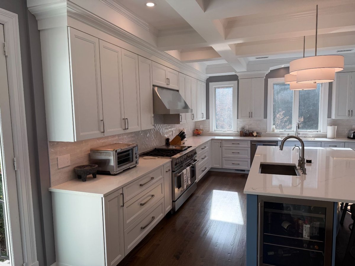 Spacious remodeled kitchen with custom cabinetry, a blue island, and quartz countertops in Chevy Chase, MD.