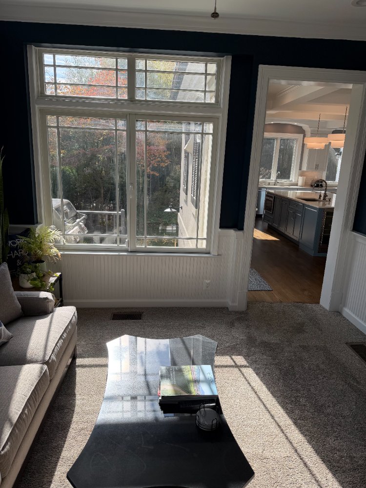 Sun-filled sitting area with oversized windows adjoining a remodeled kitchen in Chevy Chase, MD.