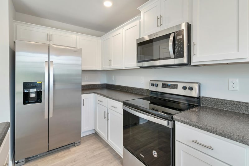 Modern white shaker kitchen with stainless steel appliances by Managed Renovations in Chevy Chase, MD stock-optimized